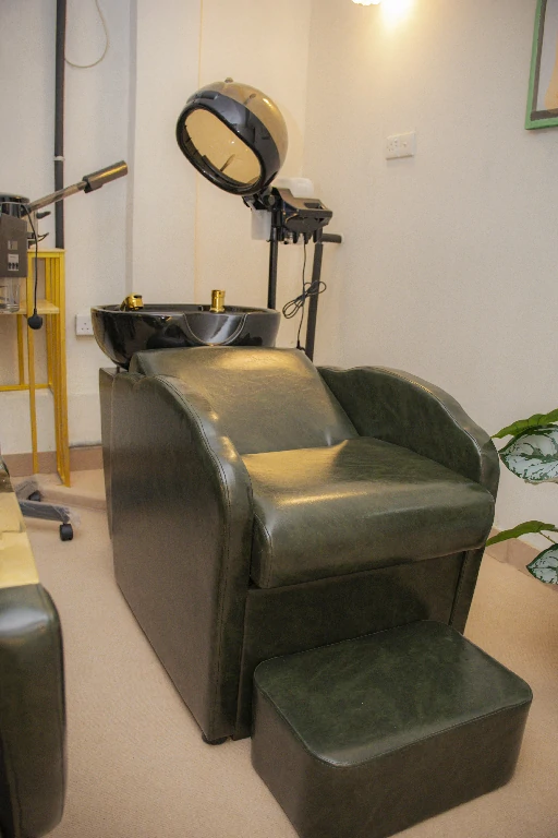 Green hair-wash chair and hooded dryer in the hair care corner