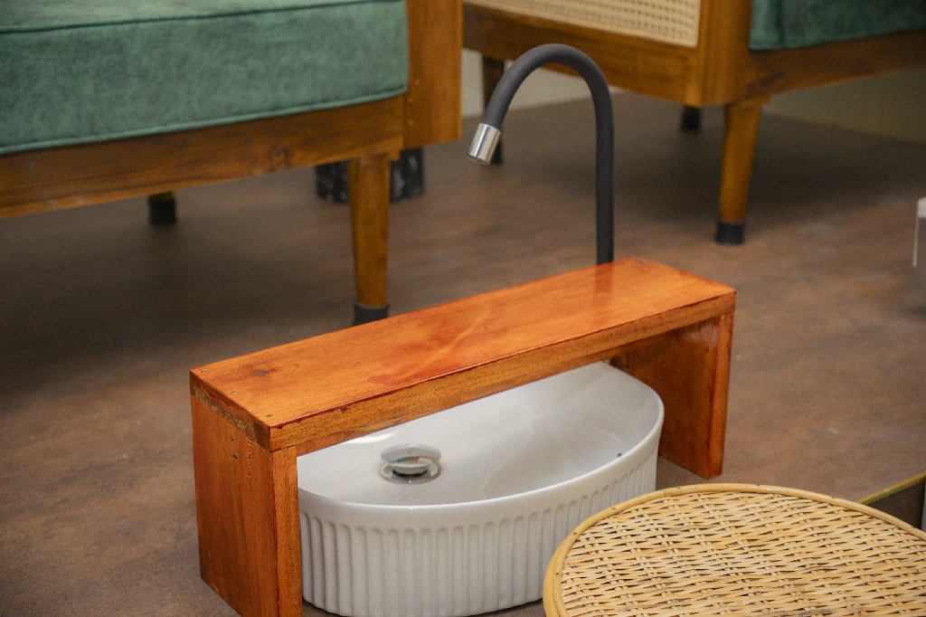 Wooden foot stool and ceramic basin beside the cane chairs